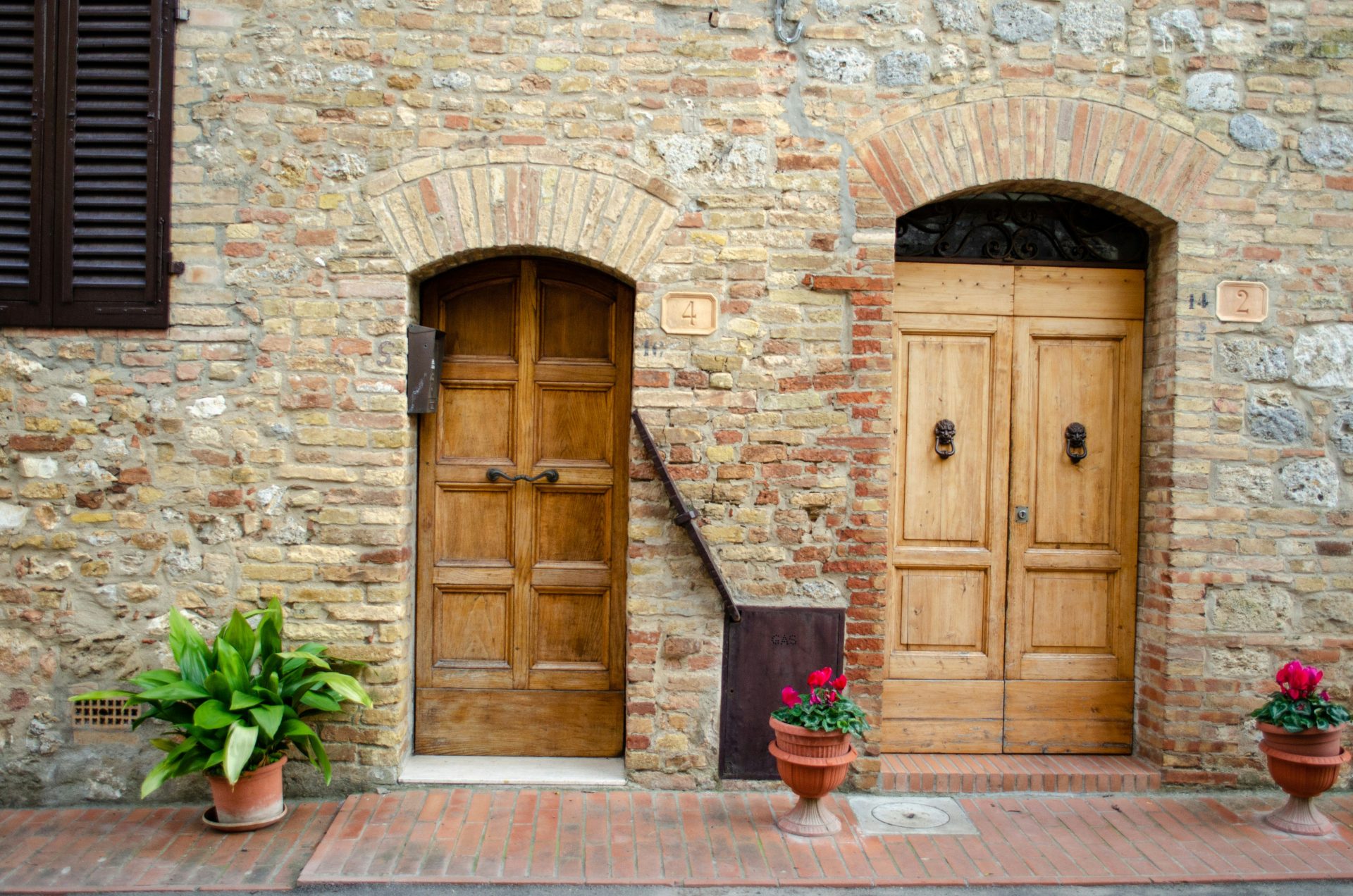 brown wooden door on brick wall